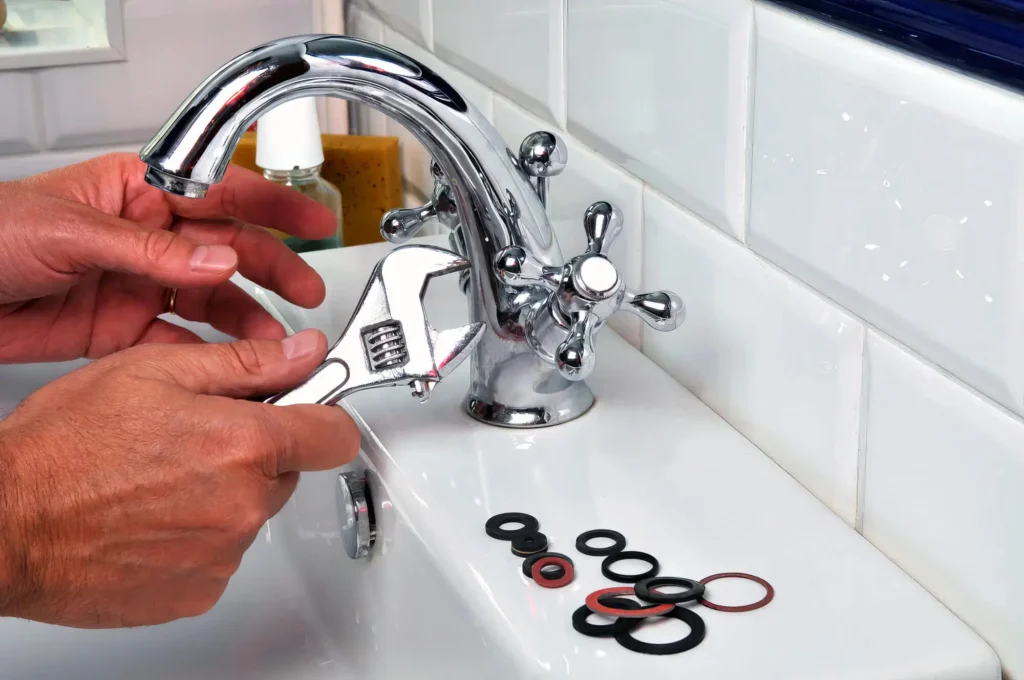 Plumber performing maintenance on a bathroom faucet in Panama City Beach