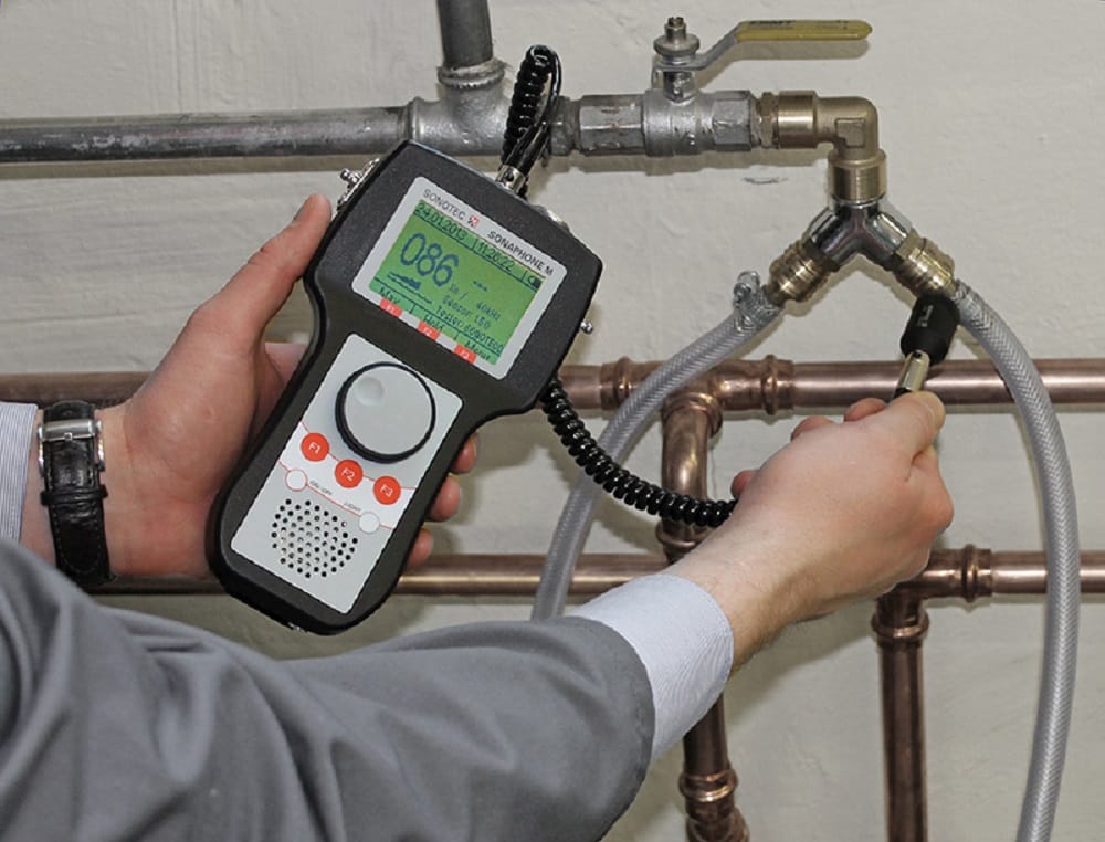Plumber testing pipes with electronic leak detection equipment in Panama City Beach