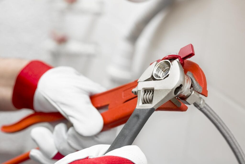 Plumber holding pipe wrenches for an emergency repair in Panama City Beach