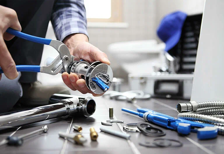 Technician repairing a plumbing fixture with professional tools in Panama City Beach