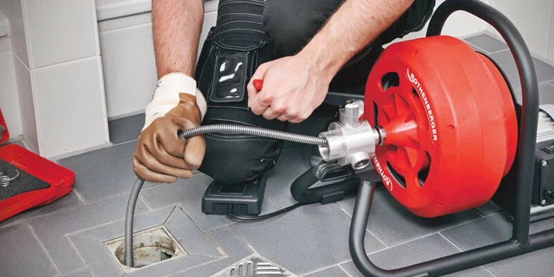 Plumber using a drain-cleaning machine in Panama City Beach