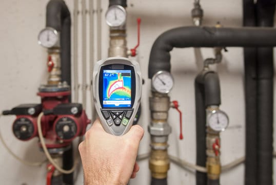 Plumber using a thermal imaging camera to inspect pipes in Panama City Beach