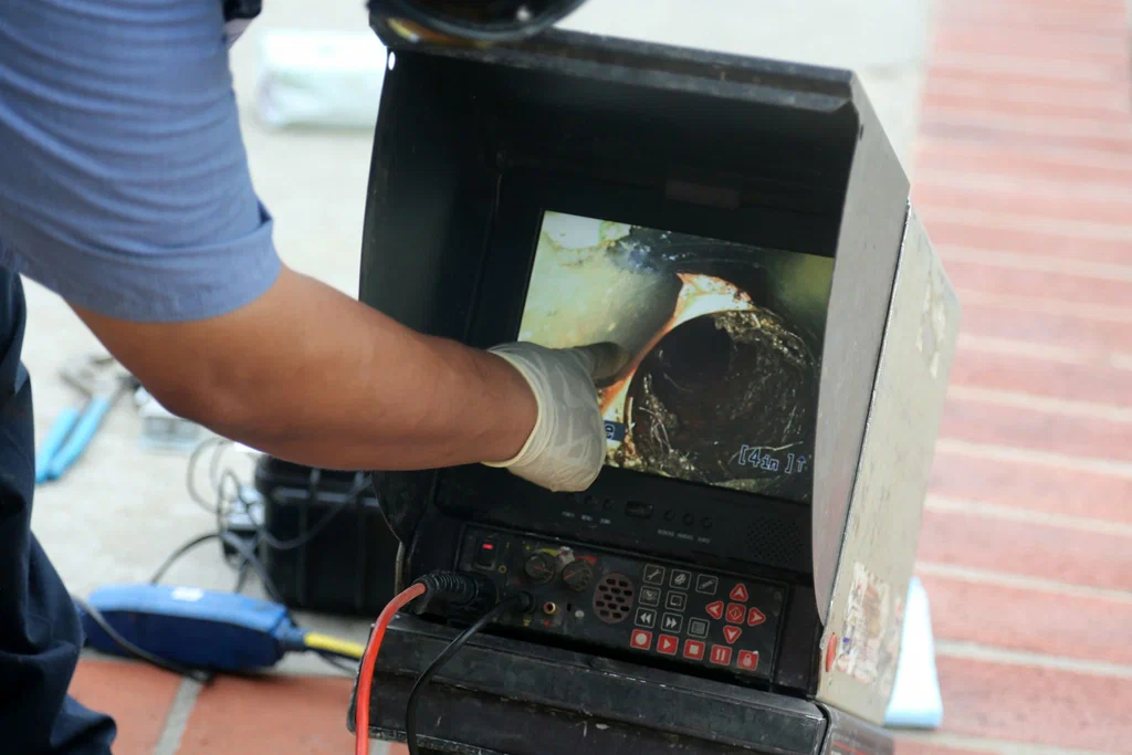 Technician viewing a drain inspection camera in Panama City Beach