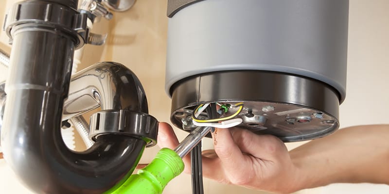 Technician repairing the heating element of a water heater in Panama City Beach