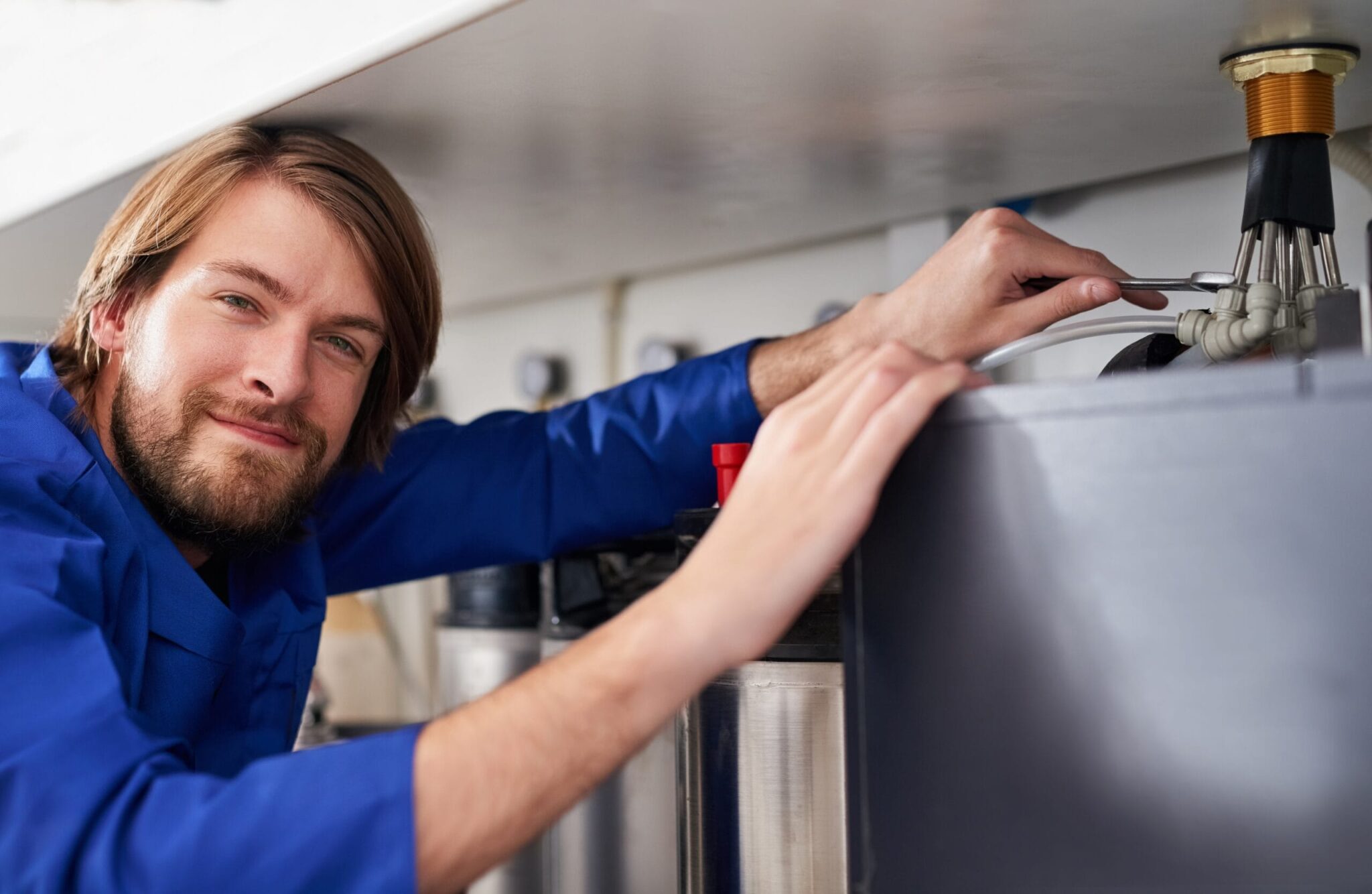 Technician servicing a residential water heater tank in Panama City Beach
