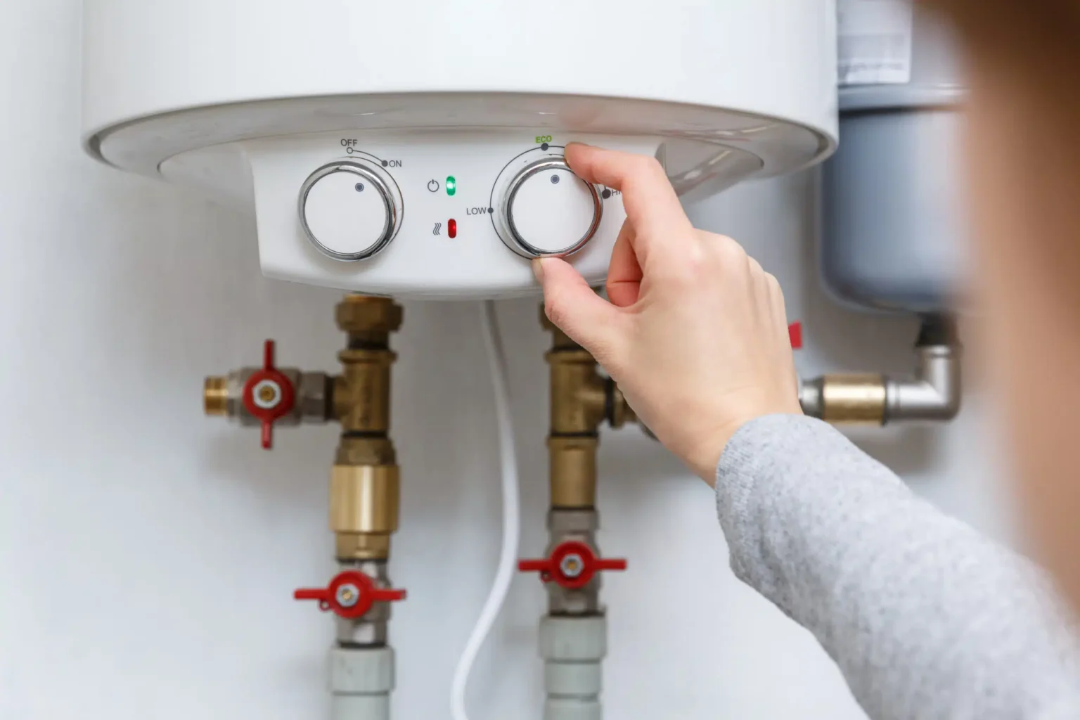 Homeowner adjusting the temperature controls on a water heater in Panama City Beach